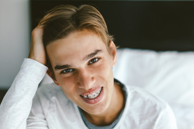 how to prevent teeth shifting boy smiling with braces to prevent teeth shifting