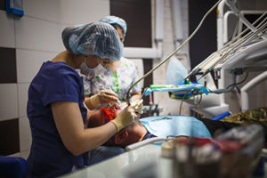 a doctor performing oral surgery on a patient