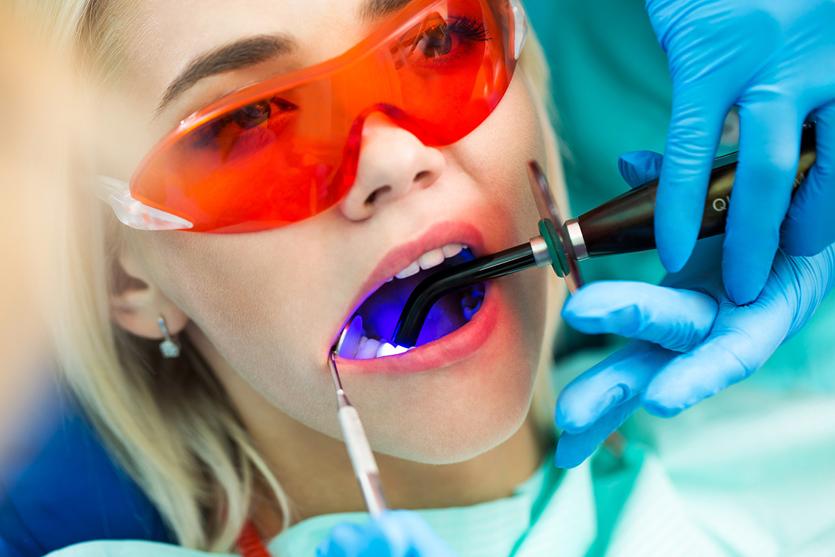 Professional Teeth Whitening Vs. At-Home woman having professional teeth whitening performed