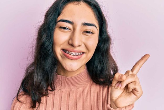 3 Benefits of Braces for Kids (1) girls shows off her braces